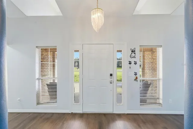 a view of a livingroom with a chandelier fan and windows