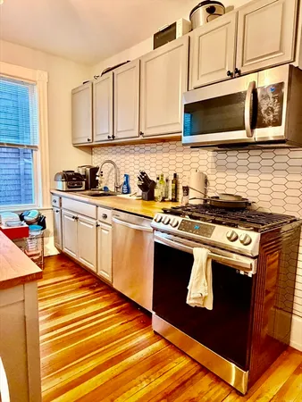 a kitchen with stainless steel appliances granite countertop a stove sink and cabinets