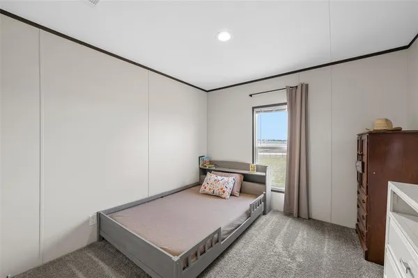 a bedroom with a bed and a refrigerator