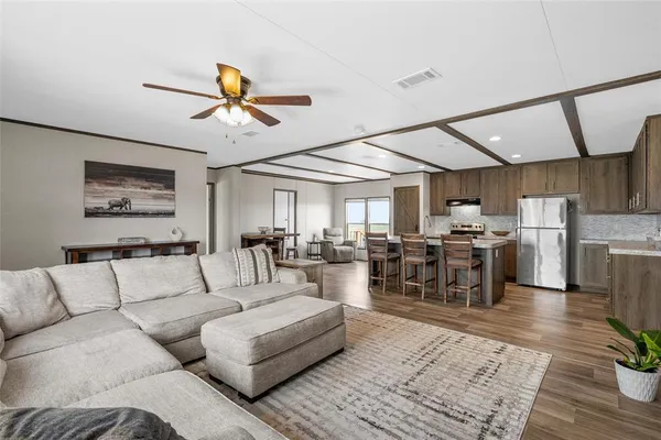a living room with furniture kitchen view and a chandelier