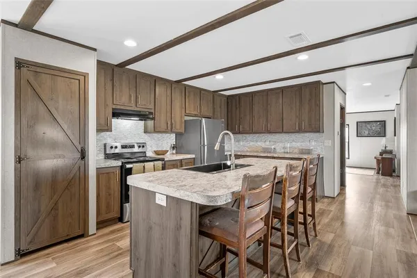 a kitchen with kitchen island a large counter top space appliances and cabinets