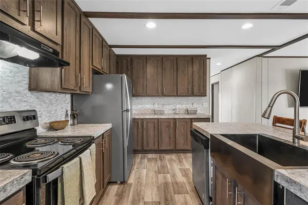 a kitchen with stainless steel appliances granite countertop a sink stove and refrigerator