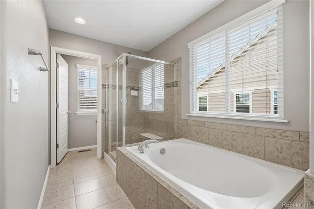 a white bath tub sitting in a bathroom next to a window