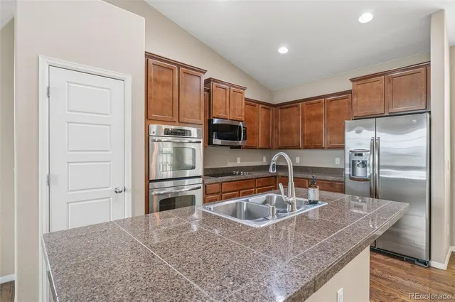 a kitchen with kitchen island granite countertop a sink stove and refrigerator
