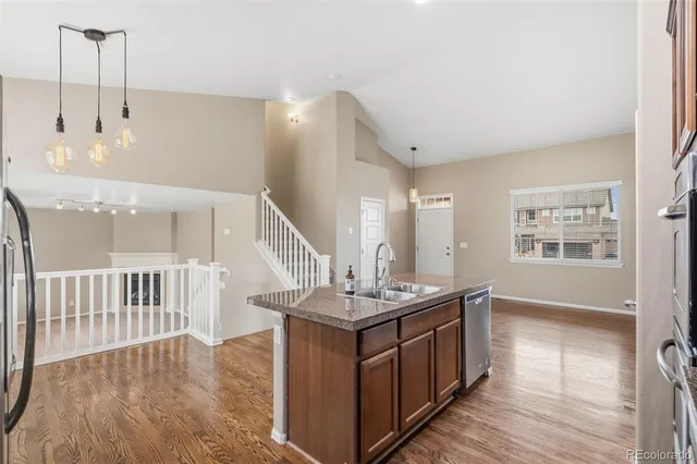 a kitchen with stainless steel appliances granite countertop a stove and a wooden floors