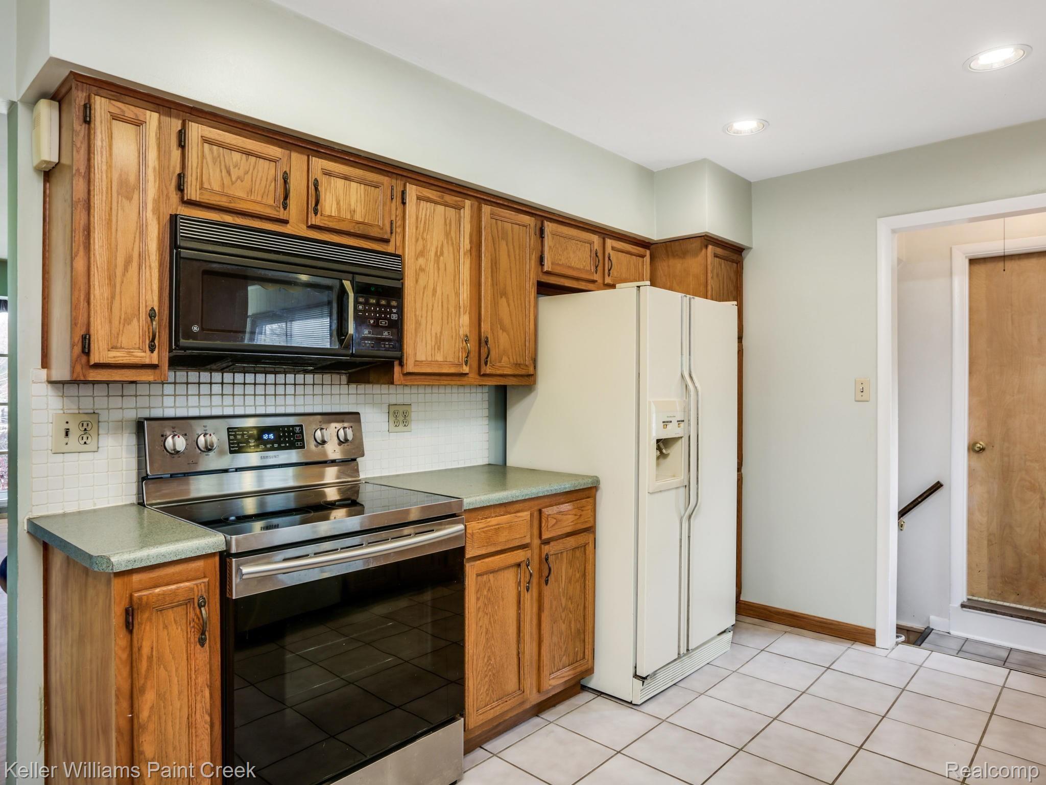 White tile backsplash and amply cabinet space. 