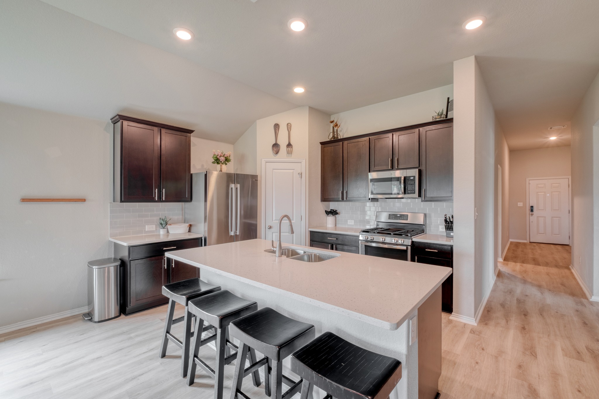 1000 Bright Star Cove Georgetown, TX 78628 - Photo 9 of 40 a kitchen with kitchen island a stove a table and chairs in it