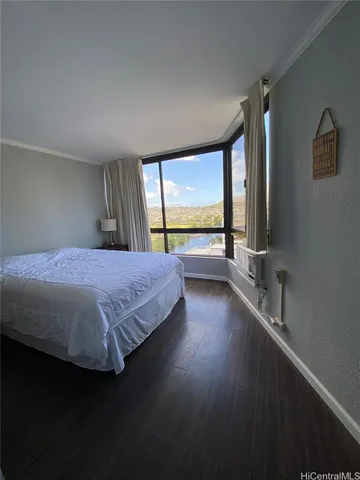 a bedroom with a large bed and large windows