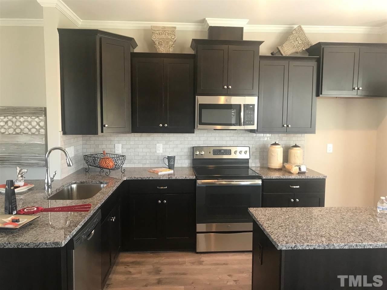 6419 Perry Creek Road Raleigh, NC 27616 - Photo 4 of 7 a kitchen with granite countertop wooden cabinets and a granite counter tops