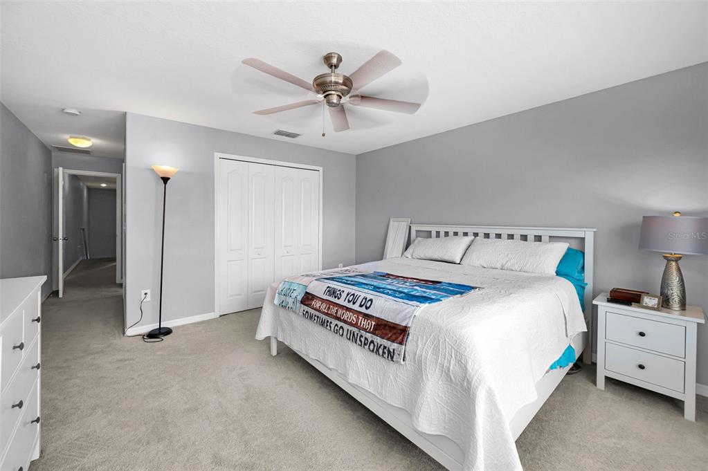 9736 Trumpet Vine Loop Trinity, FL 34655 - Photo 23 of 35 a bedroom with a bed and a chandelier