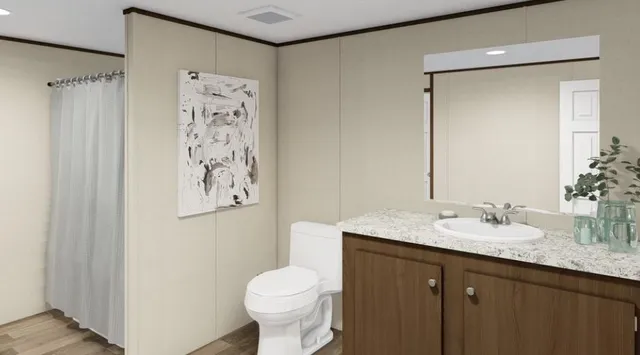 a bathroom with a granite countertop sink toilet and shower