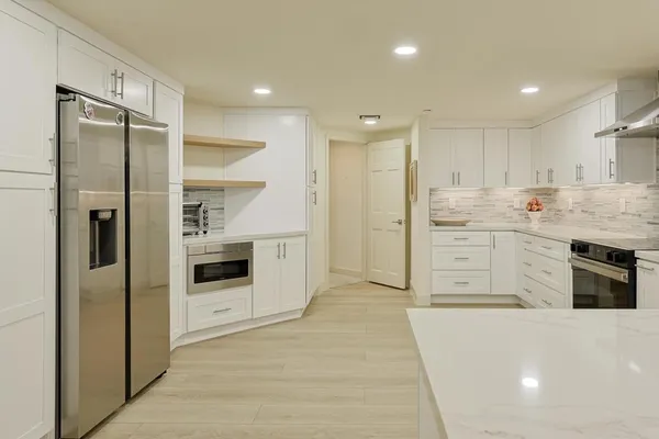 a kitchen with white cabinets and stainless steel appliances