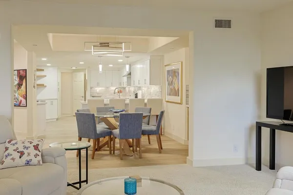 a living room with furniture a dining table and kitchen view
