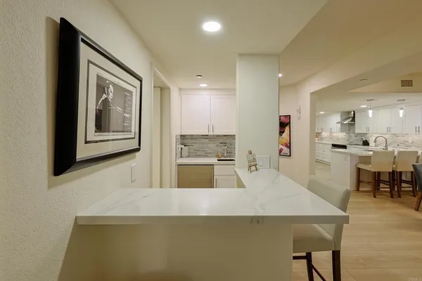 a view of a livingroom with furniture and a refrigerator