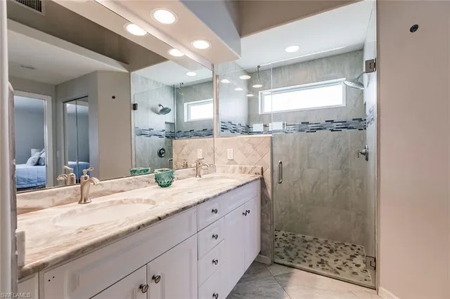 a bathroom with a granite countertop sink mirror and shower