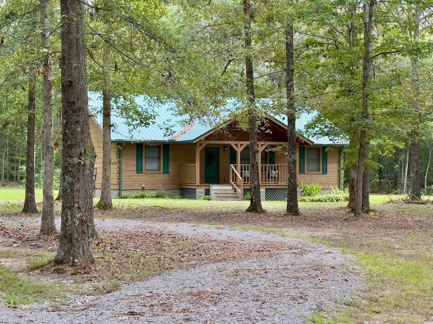 a front view of a house with a garden and trees