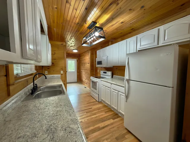 a kitchen with granite countertop a refrigerator a sink and dishwasher