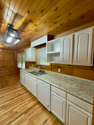 a large kitchen with stainless steel appliances granite countertop a sink and cabinets
