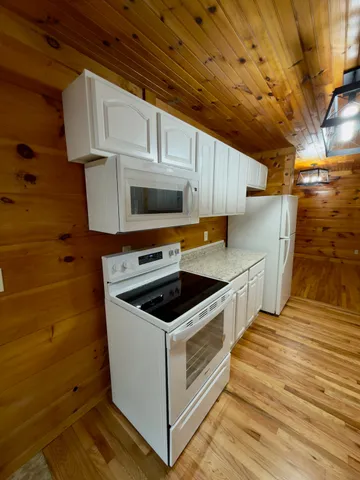 a kitchen with granite countertop a sink a stove and cabinets