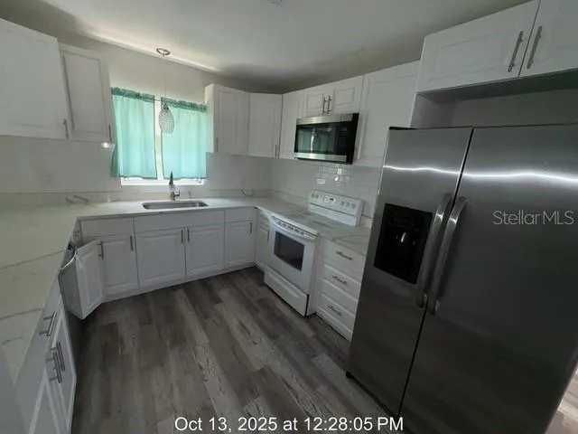 a kitchen with stainless steel appliances a sink stove and refrigerator