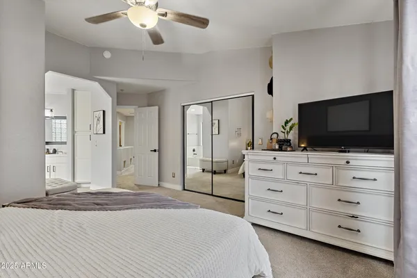 a spacious bedroom with a bed and a cabinets