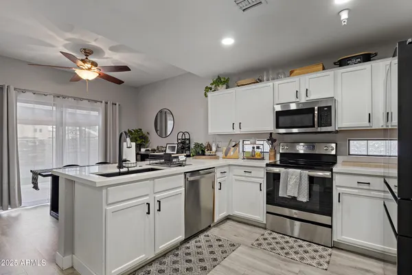 a kitchen with stainless steel appliances a sink a stove a refrigerator cabinets and a counter top space