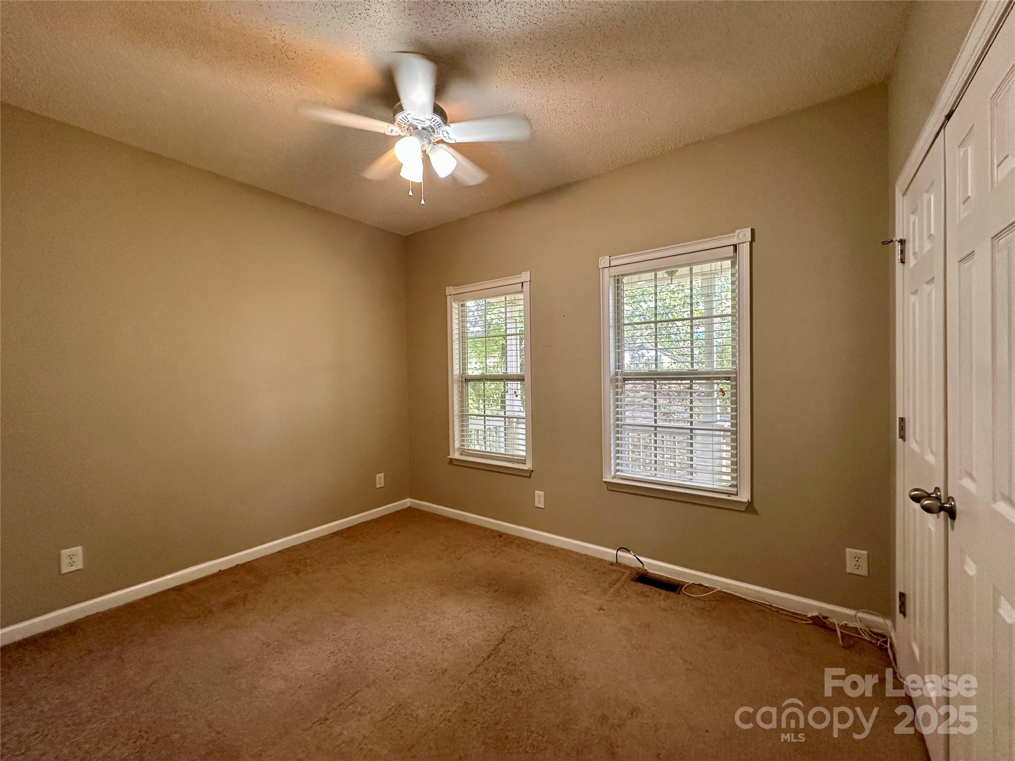 3331 Robinwood Road Gastonia, NC 28054 - Photo 14 of 14 an empty room with chandelier fan and windows