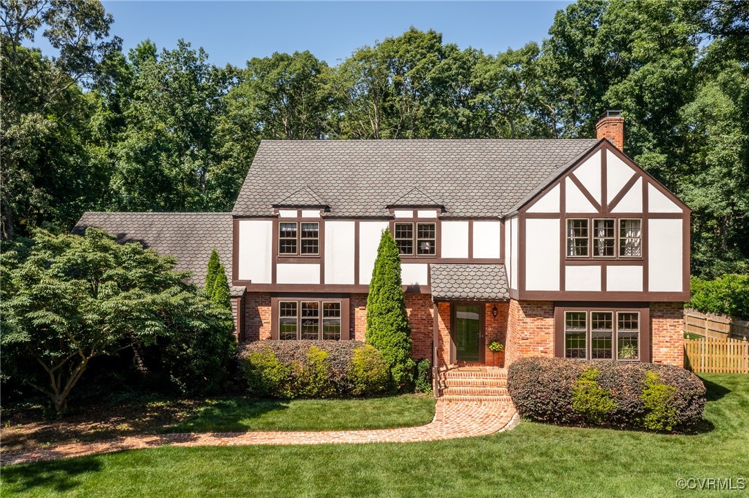a front view of a house with a yard and trees