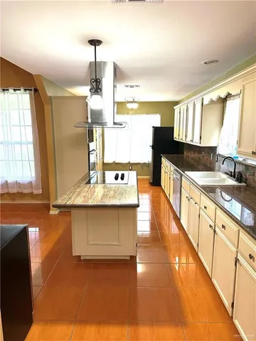 a view of a kitchen with granite countertop a sink and a wooden floor