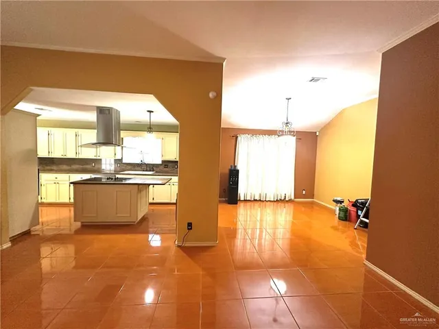 a view of a kitchen with kitchen island a counter top space a sink a refrigerator and window