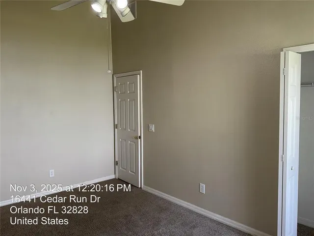 an empty room with a ceiling fan and window