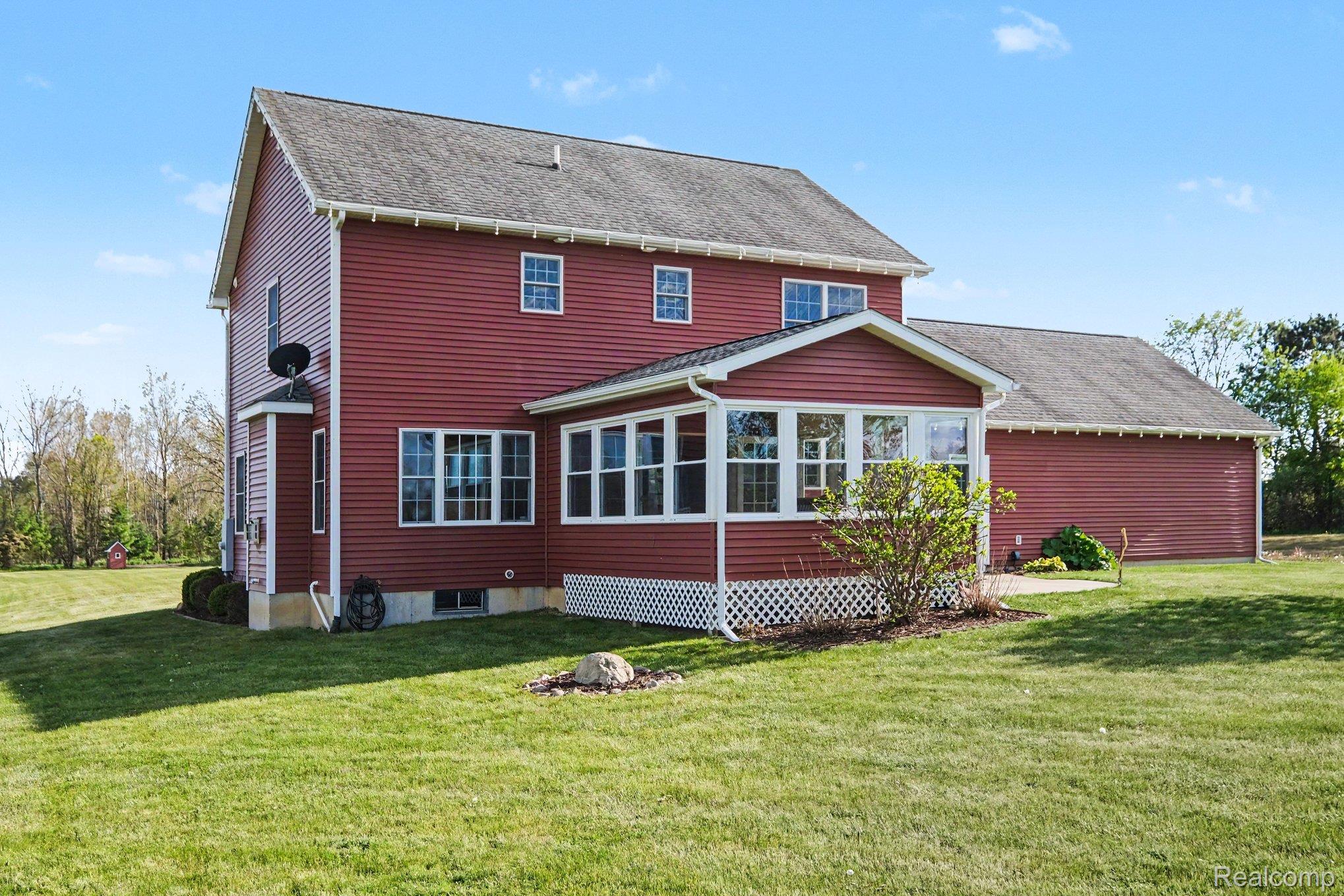 6520 Cook Road Swartz Creek, MI 48473 - Photo 36 of 43 Rear view of property featuring a sunroom, a yard, and roof with shingles