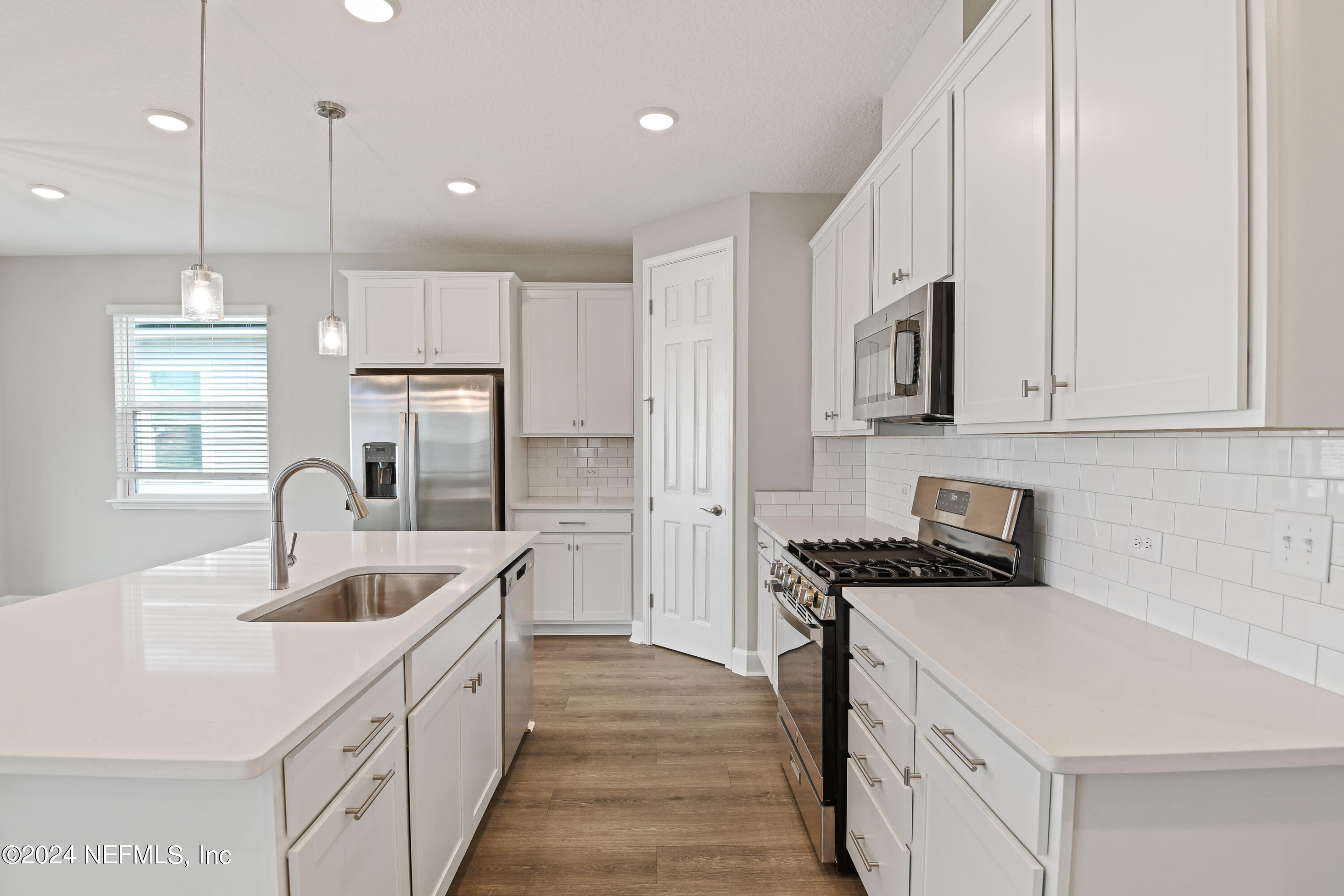 29 Cedar Elm Way St. Augustine, FL 32092 - Photo 4 of 28 a kitchen with kitchen island granite countertop a sink a counter space appliances and cabinets
