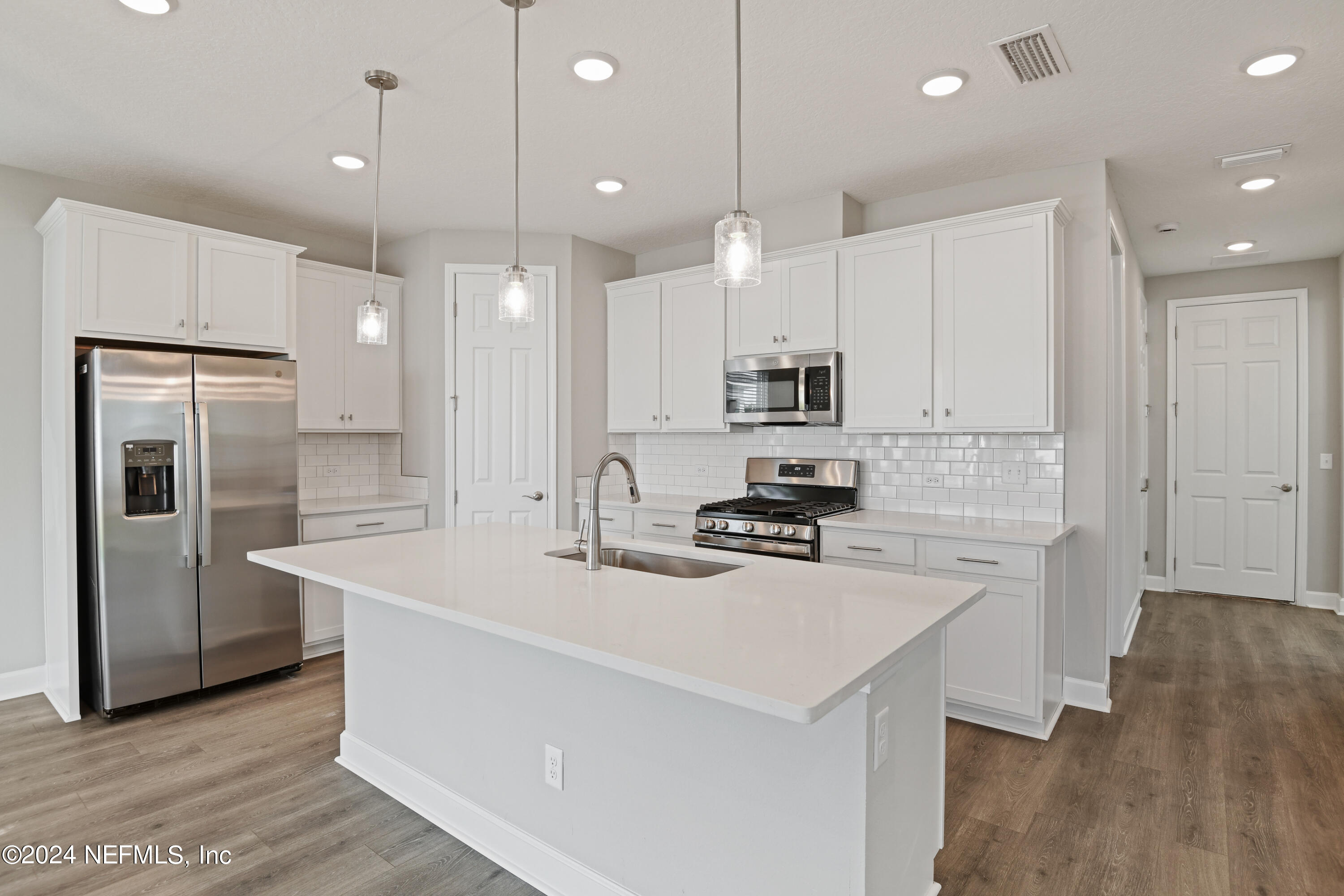 29 Cedar Elm Way St. Augustine, FL 32092 - Photo 5 of 28 a kitchen with kitchen island a white counter top space cabinets and stainless steel appliances