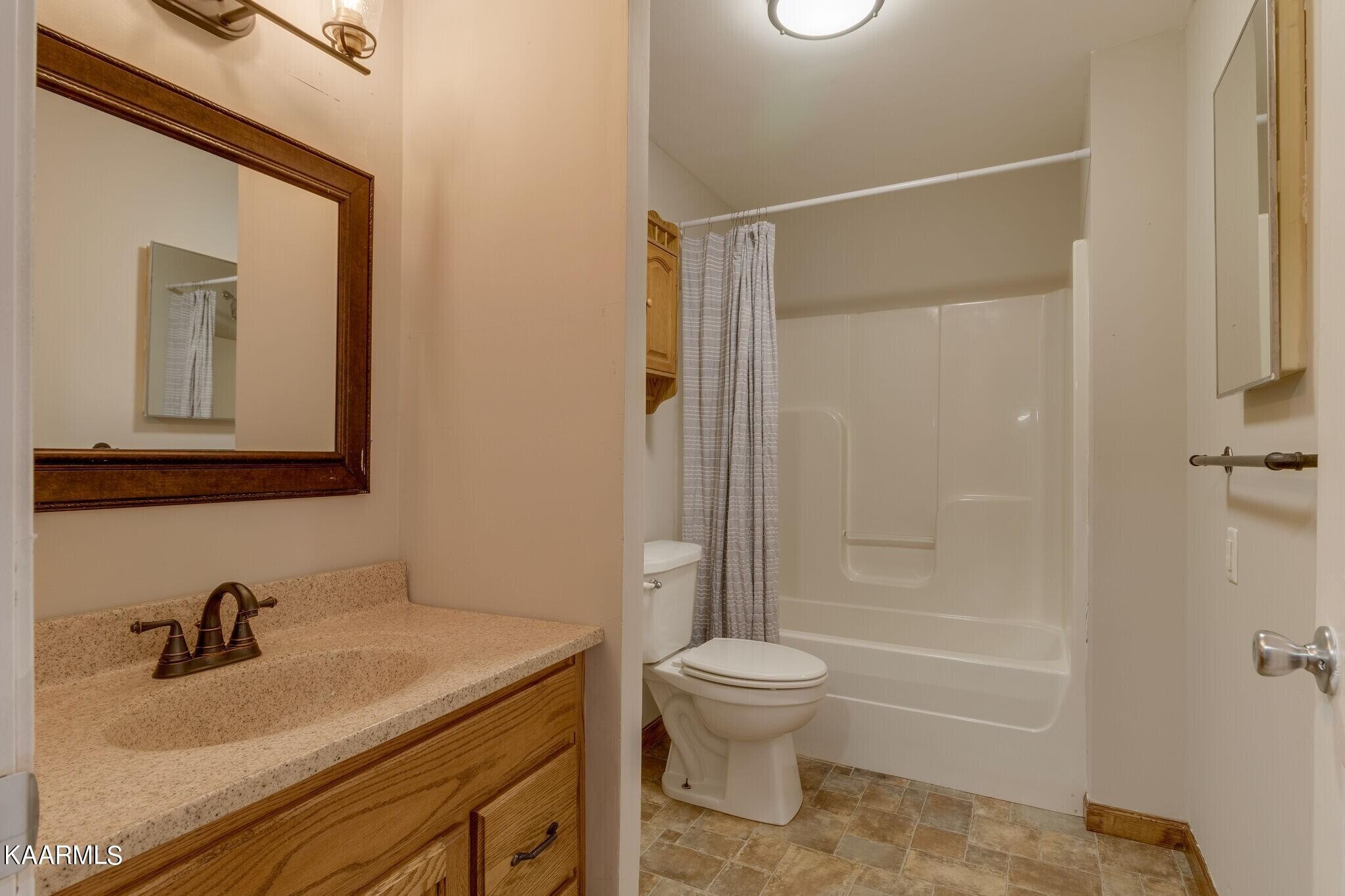 108 Davidson Street Deer Lodge, TN 37726 - Photo 13 of 30 a bathroom with a granite countertop sink toilet and shower