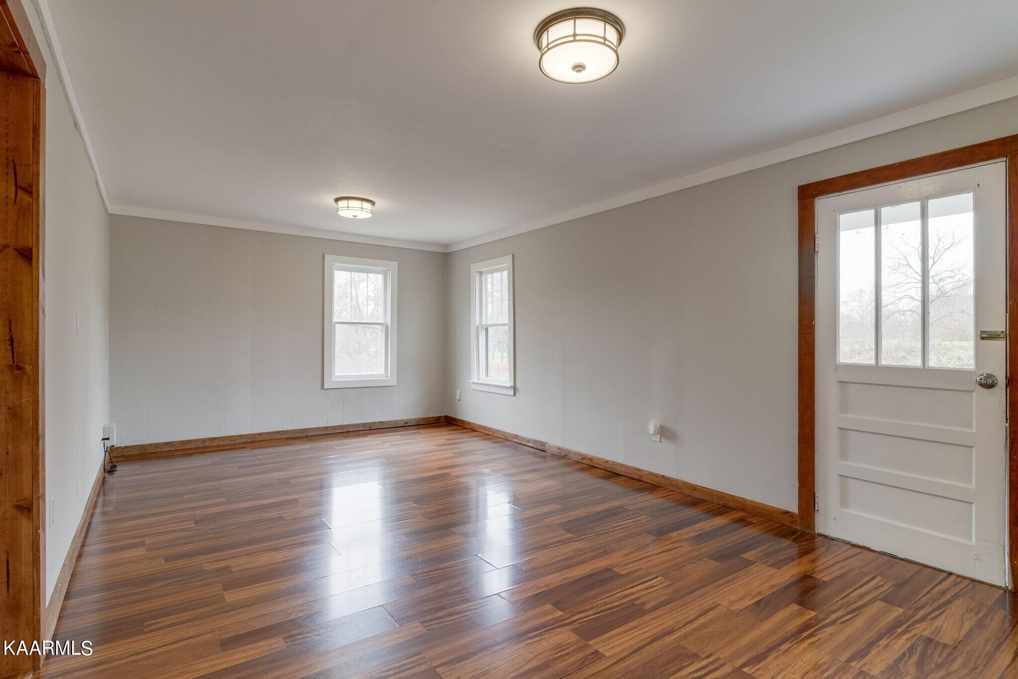 108 Davidson Street Deer Lodge, TN 37726 - Photo 4 of 30 an empty room with wooden floor and windows