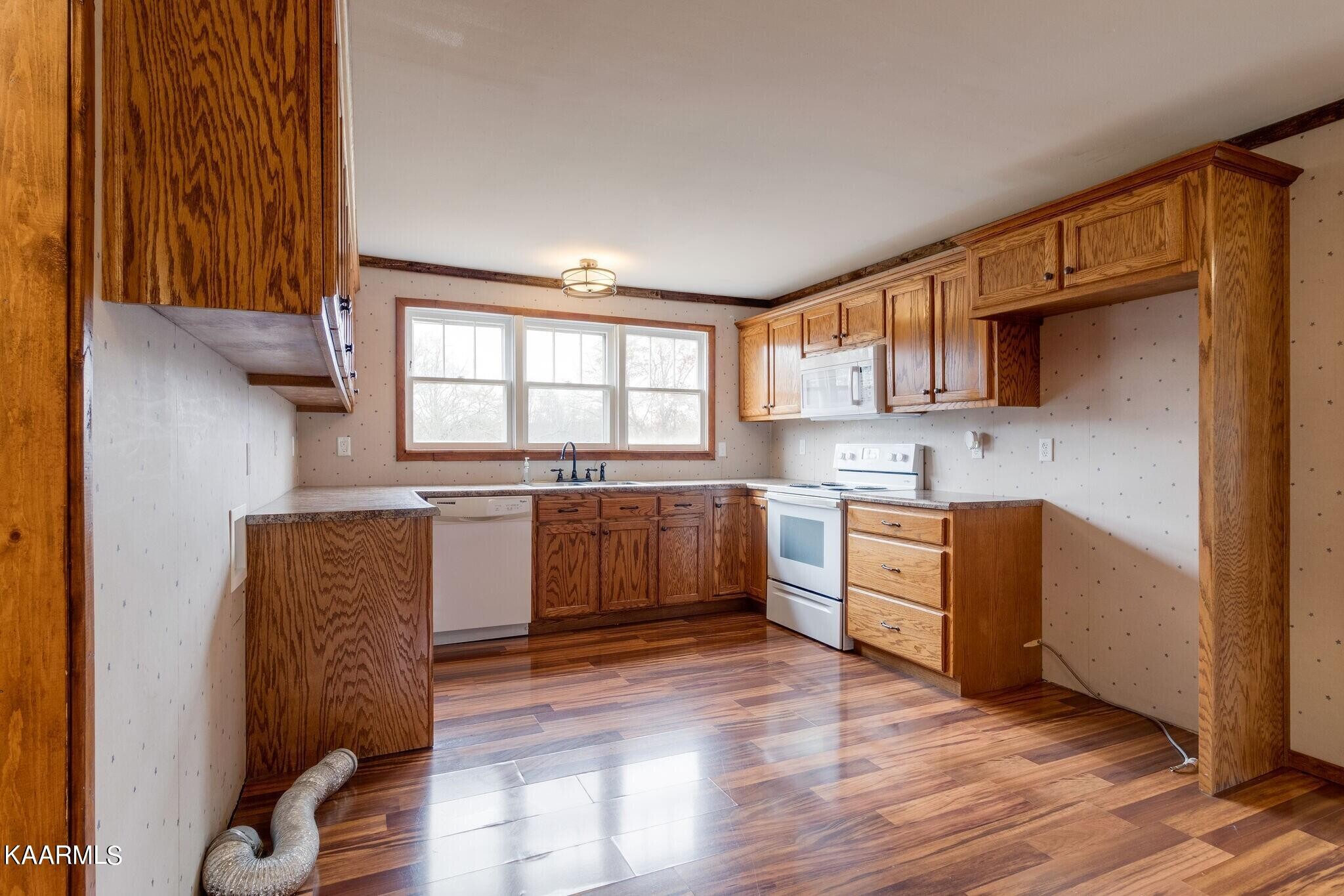 108 Davidson Street Deer Lodge, TN 37726 - Photo 8 of 30 a kitchen with granite countertop a refrigerator and wooden cabinets