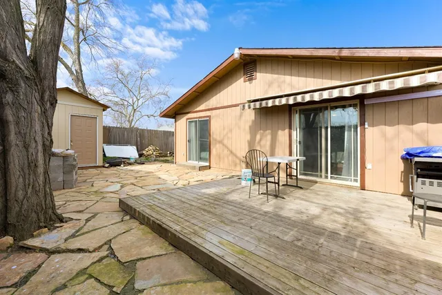 a backyard of a house with table and chairs