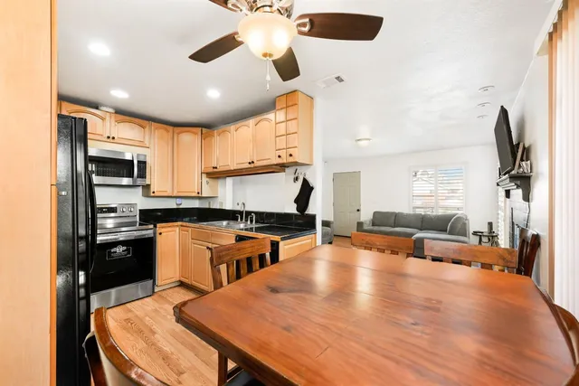 a kitchen with stainless steel appliances granite countertop a stove refrigerator a oven a sink with island and chairs