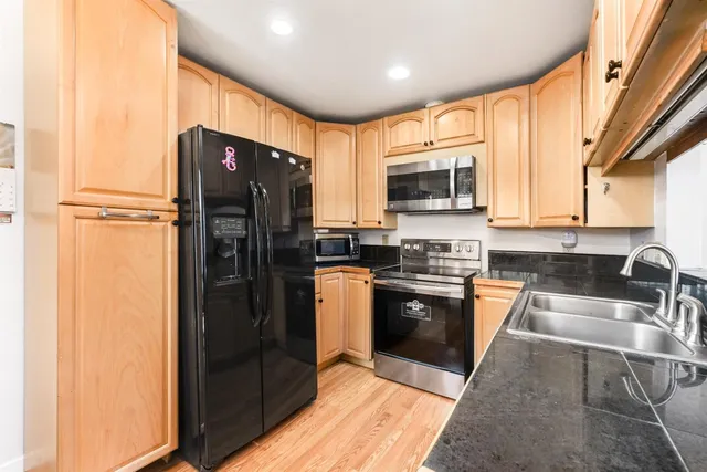 a kitchen with stainless steel appliances granite countertop a refrigerator stove and sink