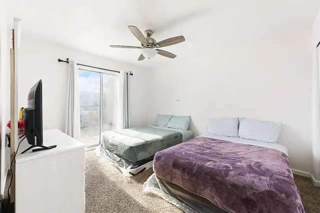 a bedroom with two beds and a flat screen tv