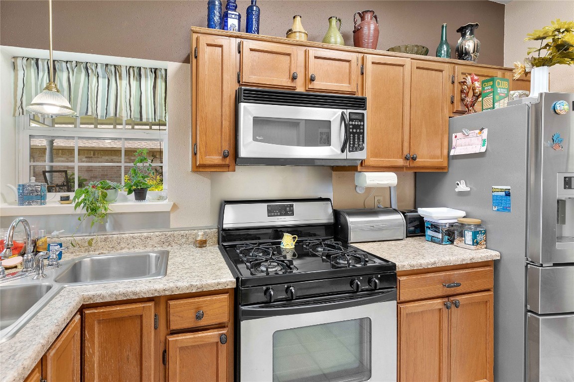 15730 Castorglen Drive Houston, TX 77598 - Photo 24 of 38 a kitchen with stainless steel appliances granite countertop a stove a sink and a microwave