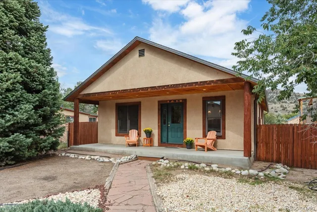 a view of a house with backyard porch and wooden fence