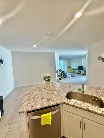 a kitchen with granite countertop a sink and cabinets