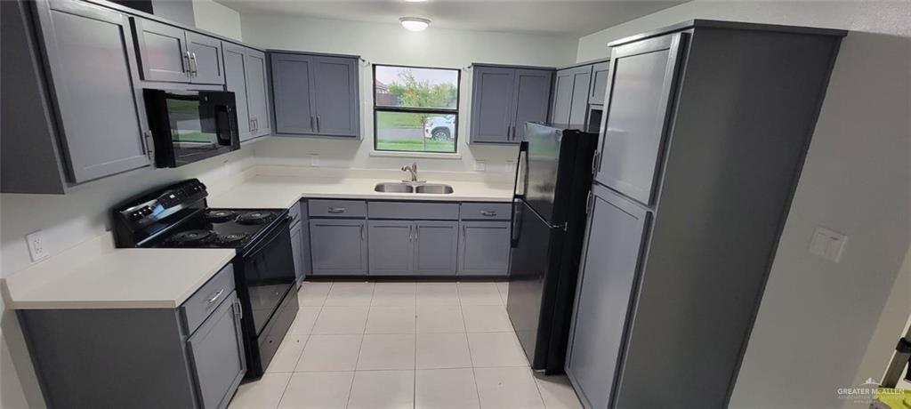 303 South Ridge Lane, Unit 1 San Juan, TX 78589 - Photo 5 of 6 a kitchen with stainless steel appliances a refrigerator stove and sink