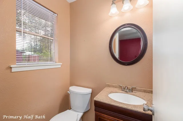 a bathroom with a toilet a sink and a mirror
