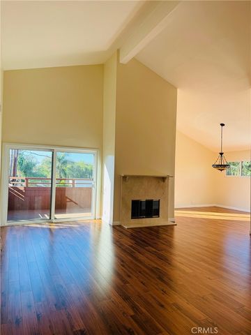 a view of empty room with wooden floor and fireplace