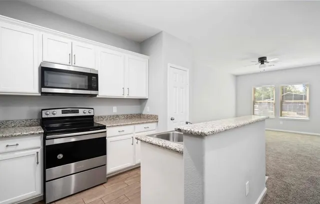 a kitchen with granite countertop a stove and a microwave