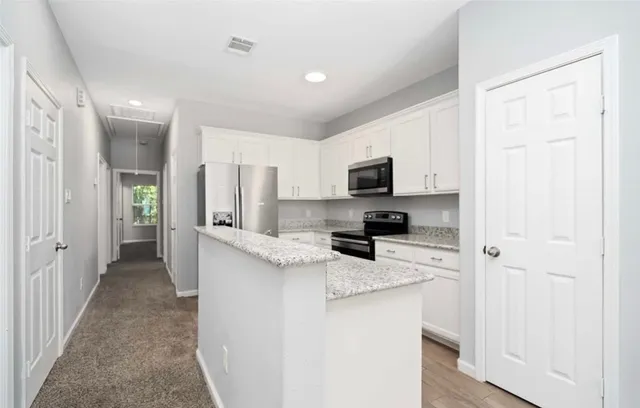 a kitchen with stainless steel appliances a refrigerator sink stove microwave and cabinets