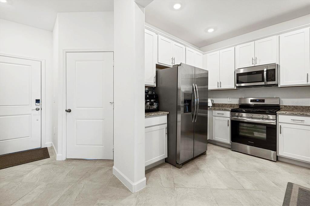 14812 Lyla Terrace Lakewood Ranch, FL 34211 - Photo 12 of 65 a kitchen with stainless steel appliances a refrigerator stove and microwave